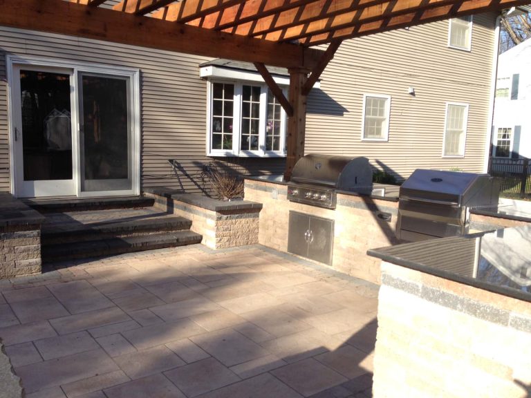 Example of a mid-sized backyard brick patio kitchen design in Other with a pergola