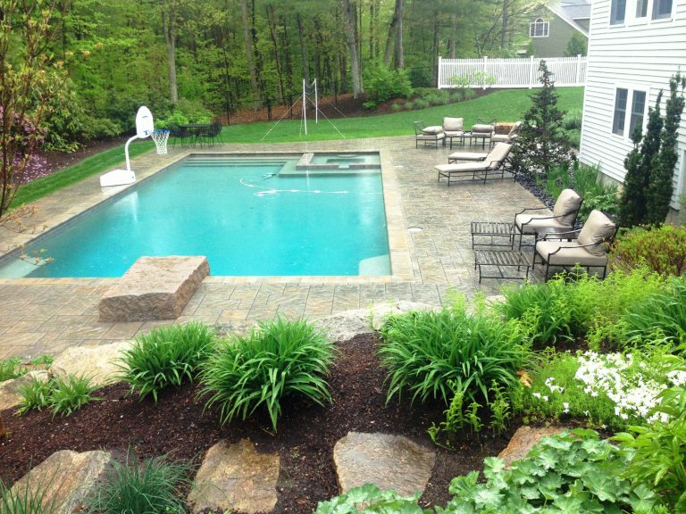 Example of a mid-sized backyard stamped concrete and custom-shaped lap hot tub design in Boston