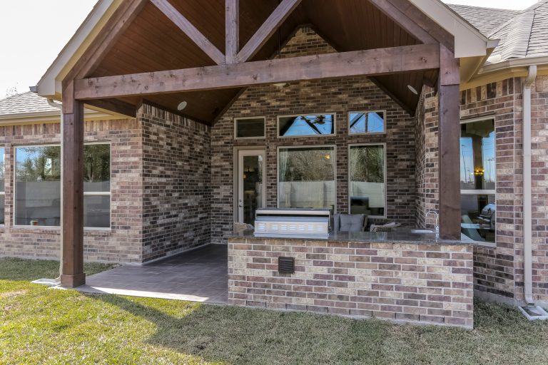 Example of a mid-sized backyard tile patio kitchen design in Houston with a roof extension