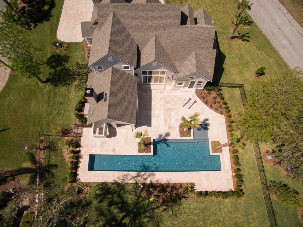 Example of a mid-sized beach style backyard concrete paver and rectangular lap pool design in Jacksonville