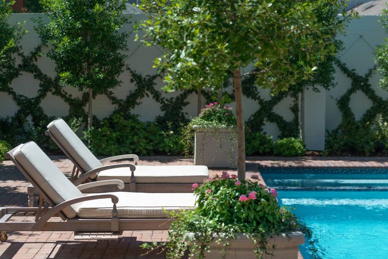Example of a mid-sized classic backyard brick and rectangular lap pool design in Dallas