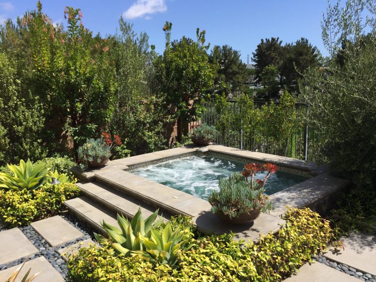 Example of a mid-sized classic backyard gravel hot tub design in Orange County