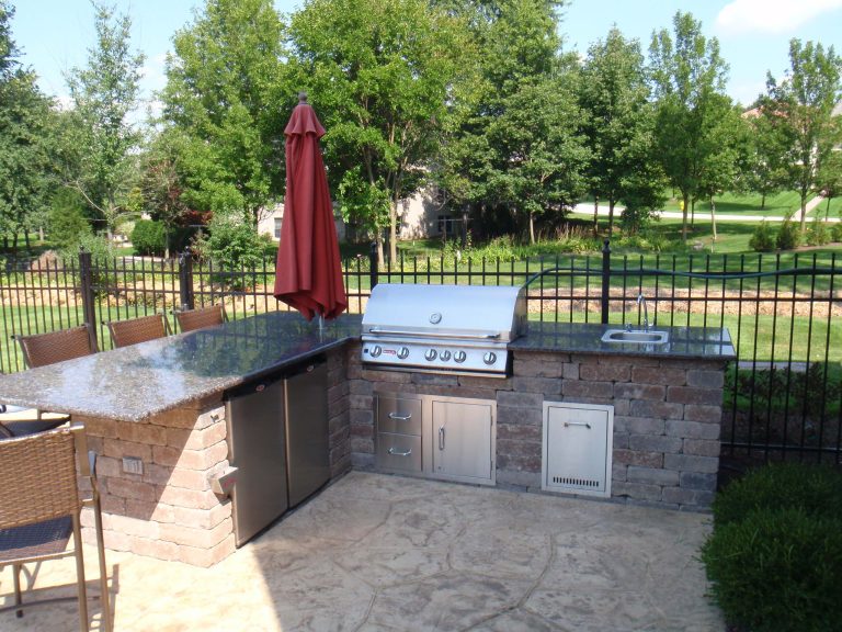 Example of a mid-sized classic backyard stamped concrete patio kitchen design in Chicago with no cover