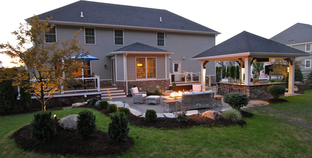 Example of a mid-sized classic backyard stamped concrete patio kitchen design in Other with a roof extension