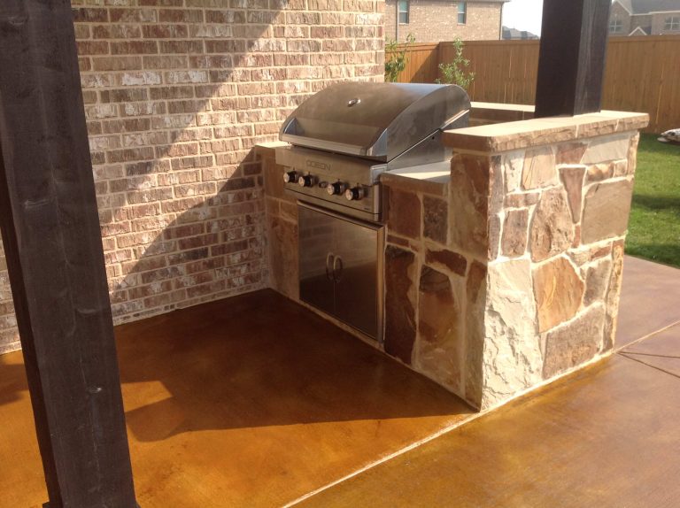 Example of a mid-sized classic backyard stamped concrete patio kitchen design with a roof extension