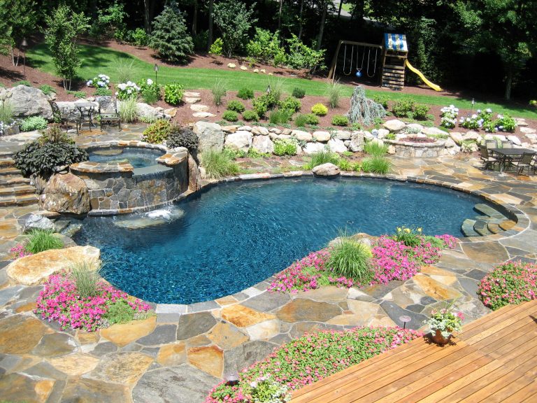 Example of a mid-sized classic backyard stone and custom-shaped natural hot tub design in New York