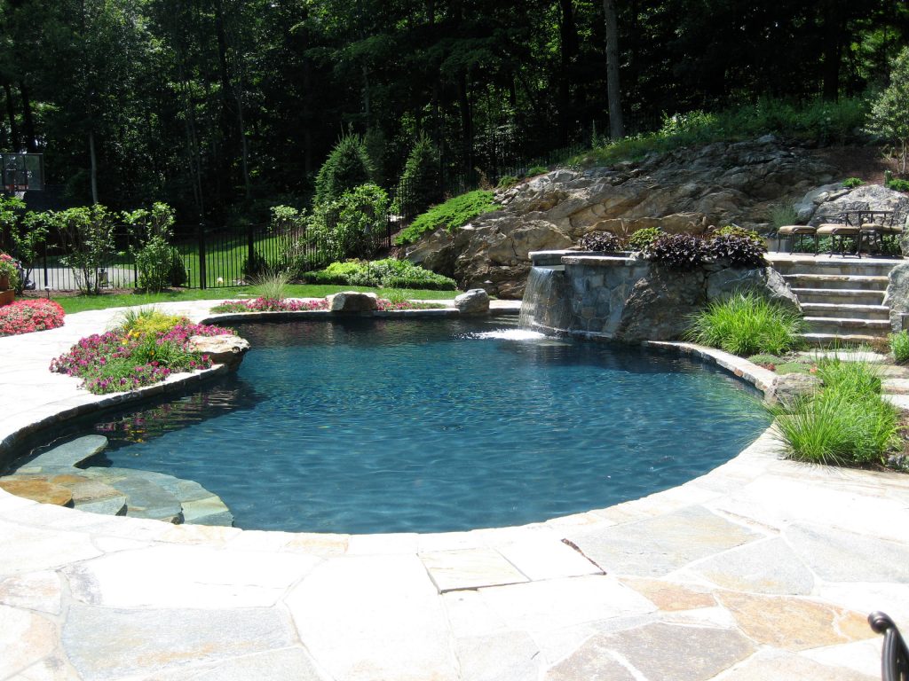Example of a mid-sized classic backyard stone and custom-shaped natural pool fountain design in New York