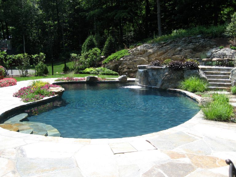 Example of a mid-sized classic backyard stone and custom-shaped natural pool fountain design in New York