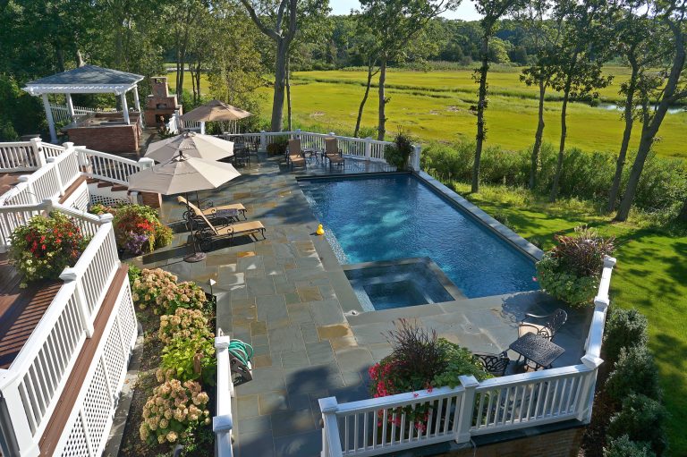 Example of a mid-sized classic backyard stone and l-shaped lap hot tub design in Other