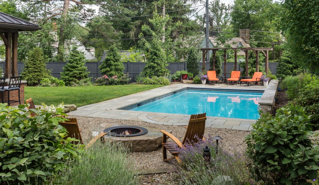 Example of a mid-sized classic backyard stone and rectangular lap pool fountain design in Cleveland