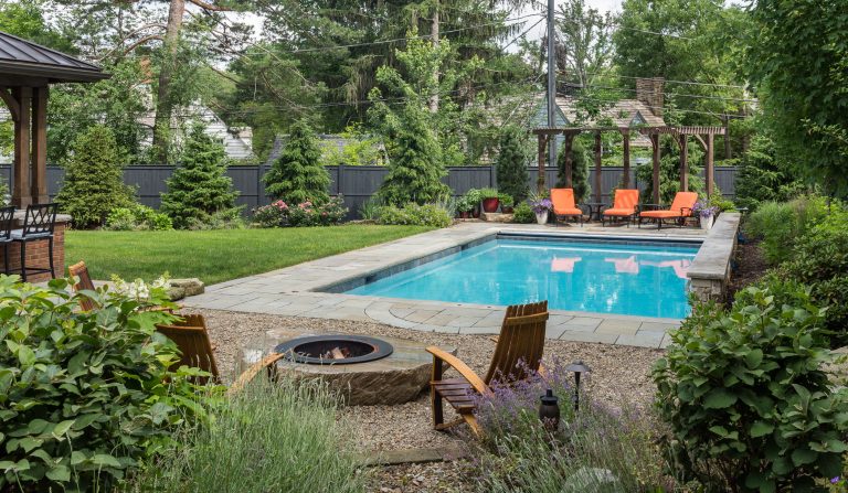 Example of a mid-sized classic backyard stone and rectangular lap pool fountain design in Cleveland