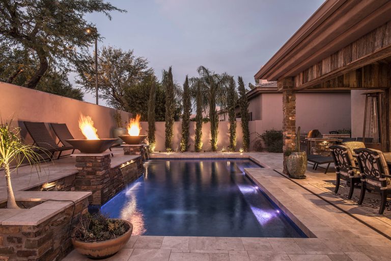 Example of a mid-sized classic backyard stone and rectangular pool design in Phoenix