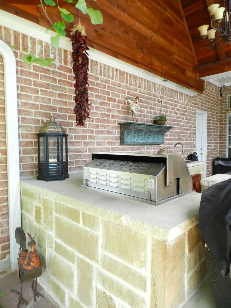 Example of a mid-sized classic backyard stone patio kitchen design in Dallas with a roof extension