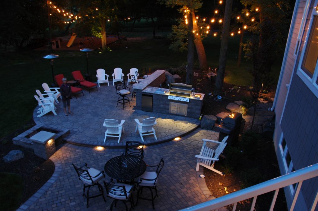 Example of a mid-sized classic backyard stone patio kitchen design in Minneapolis with no cover