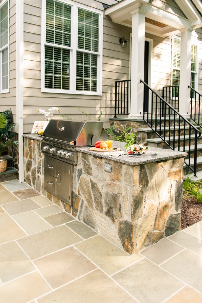 Example of a mid-sized classic backyard stone patio kitchen design in Richmond with no cover