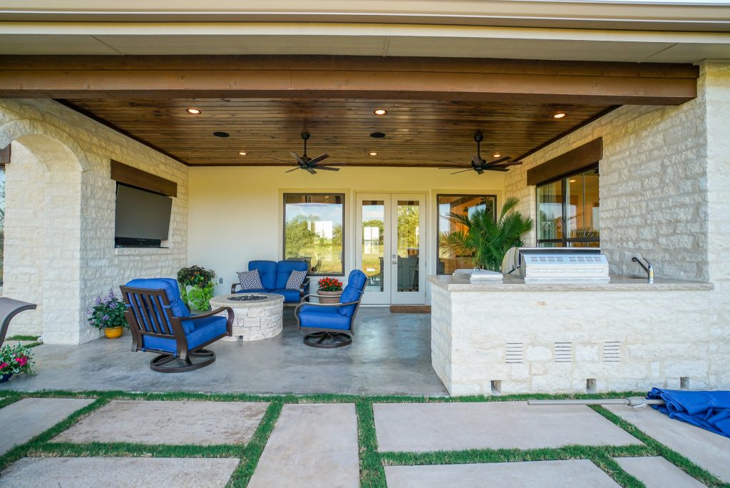 Example of a mid-sized cottage backyard concrete patio kitchen design in Austin with a roof extension