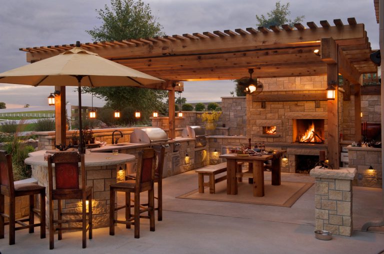Example of a mid-sized country backyard concrete patio kitchen design in Kansas City with a gazebo