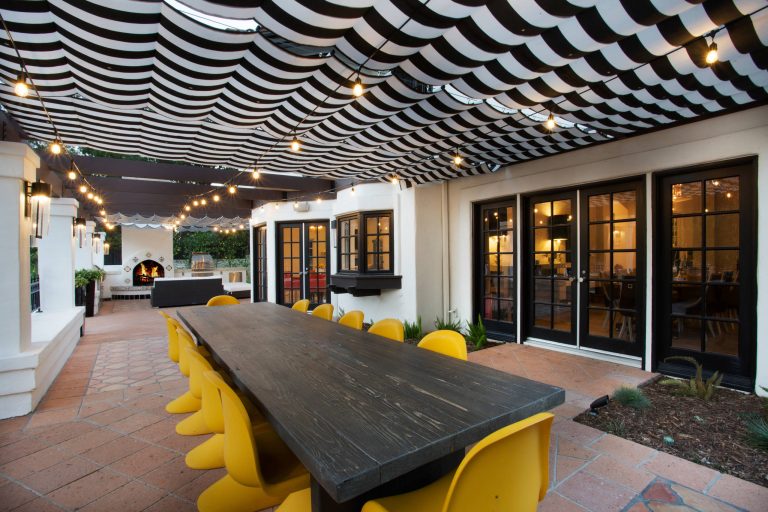 Example of a mid-sized eclectic side yard tile patio kitchen design in Los Angeles with an awning