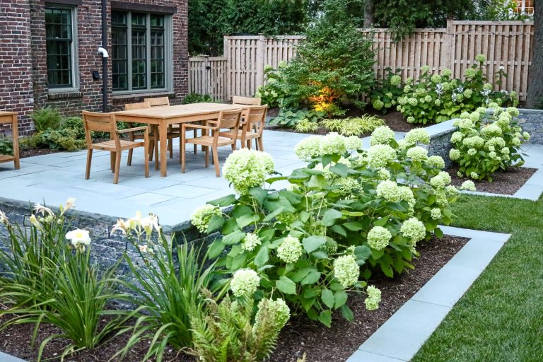 Example of a mid-sized french country backyard stone patio kitchen design in Boston