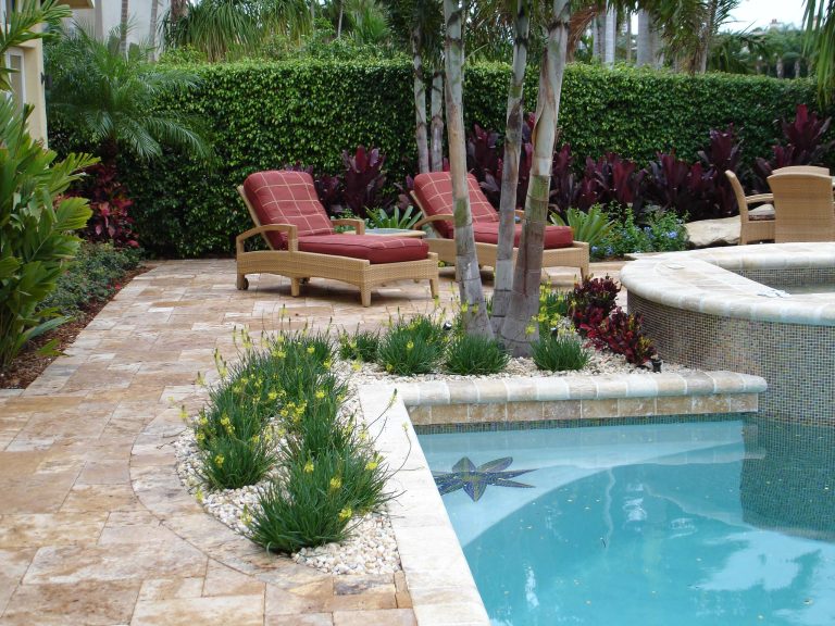 Example of a mid-sized island style backyard stone and rectangular infinity hot tub design in Miami