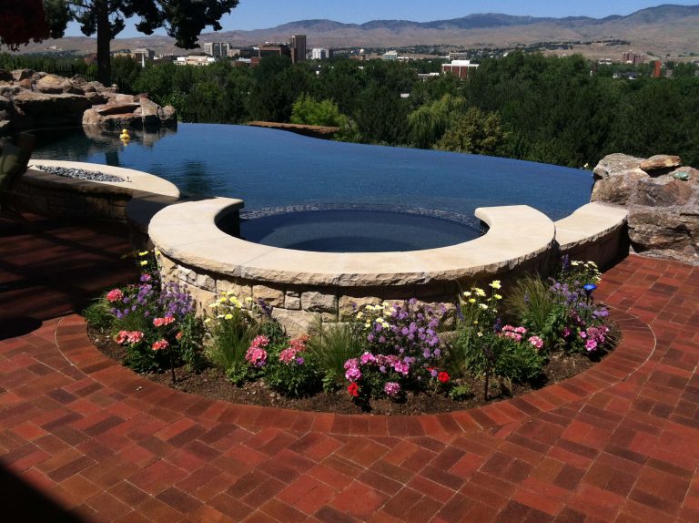 Example of a mid-sized minimalist backyard brick and custom-shaped infinity hot tub design in Boise
