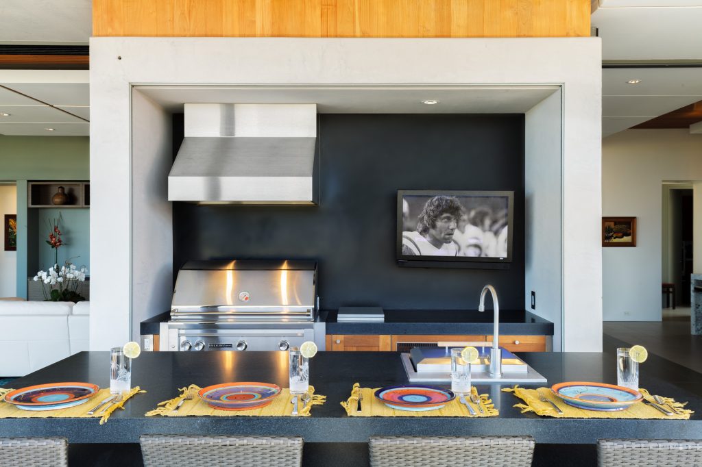 Example of a mid-sized minimalist backyard concrete patio kitchen design in Hawaii with a roof extension