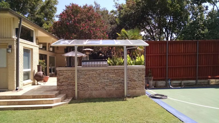 Example of a mid-sized minimalist backyard outdoor kitchen deck design in Seattle with an awning