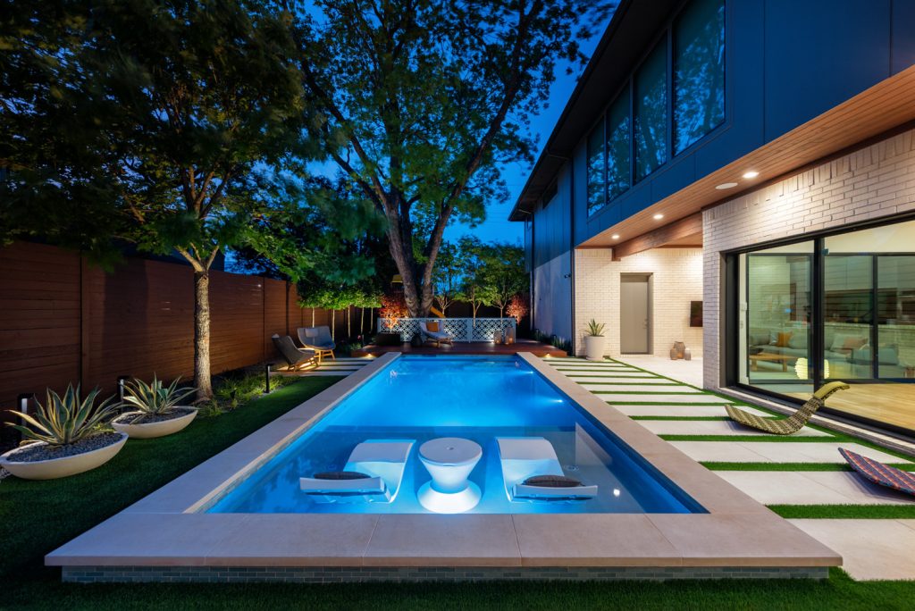 Example of a mid-sized minimalist backyard stone and rectangular pool design in Dallas