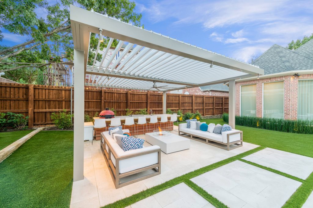Example of a mid-sized minimalist backyard stone patio kitchen design in Dallas with a pergola