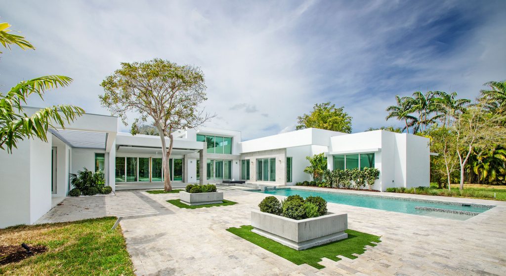 Example of a mid-sized minimalist backyard tile patio kitchen design in Miami with a pergola