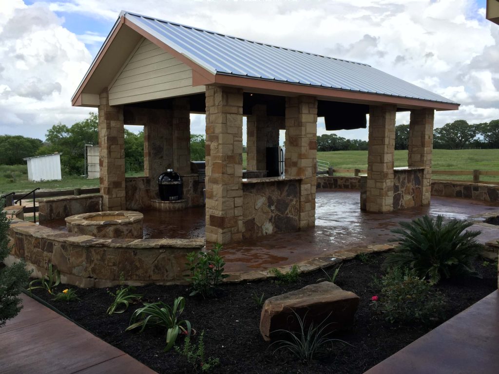 Example of a mid-sized mountain style backyard concrete patio kitchen design in Austin with a gazebo