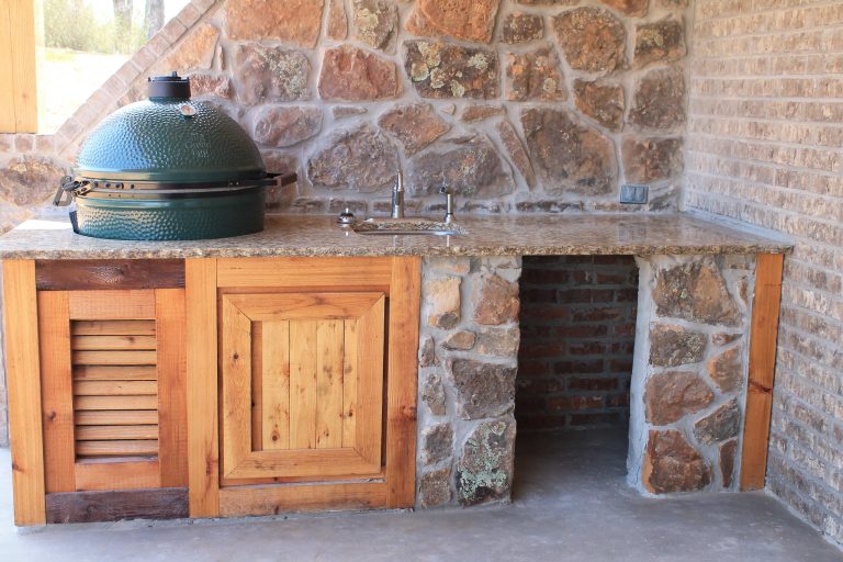 Example of a mid-sized mountain style backyard concrete patio kitchen design in Dallas with a roof extension