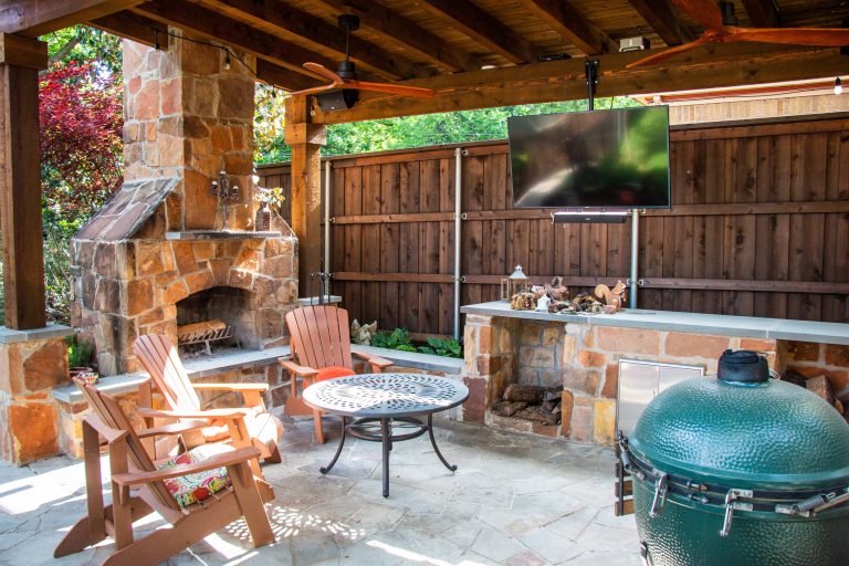 Example of a mid-sized mountain style backyard stone patio kitchen design in Dallas with a gazebo