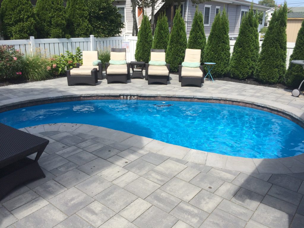 Example of a mid-sized transitional backyard concrete paver and kidney-shaped lap pool design in Philadelphia