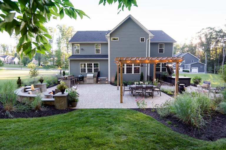 Example of a mid-sized transitional backyard concrete paver patio kitchen design in Richmond with a pergola