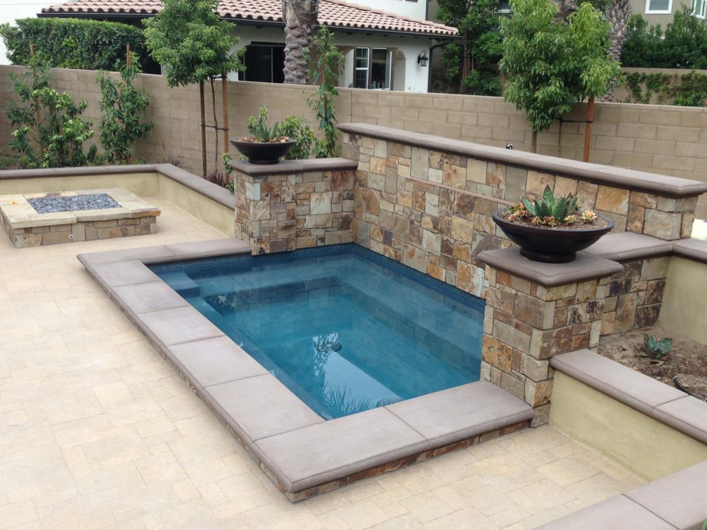 Example of a mid-sized transitional backyard stone pool fountain design in Orange County