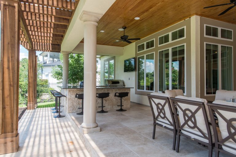 Example of a mid-sized transitional backyard tile patio kitchen design in Houston with a roof extension