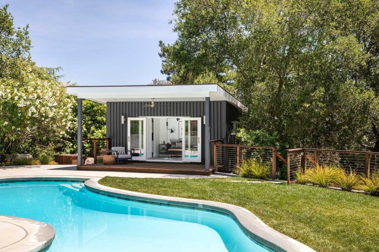 Example of a mid-sized trendy backyard concrete and custom-shaped pool house design in Boise