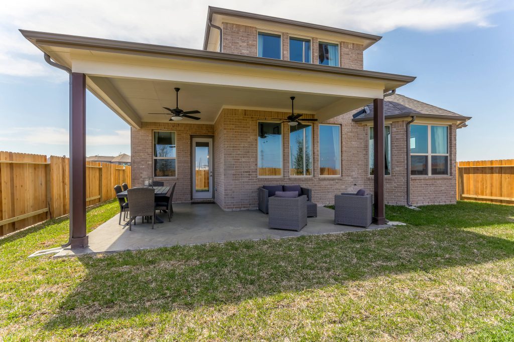 Example of a mid-sized trendy backyard concrete patio kitchen design in Houston with a roof extension