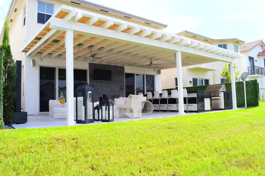 Example of a mid-sized trendy backyard concrete paver patio kitchen design in Miami with an awning