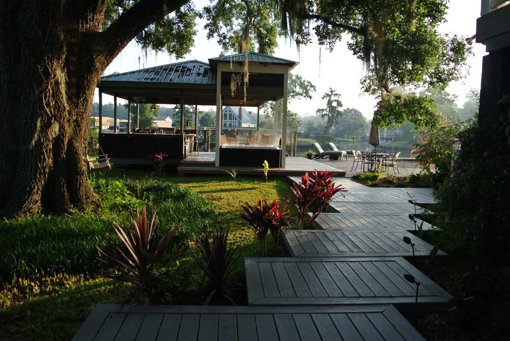 Example of a mid-sized trendy backyard outdoor kitchen deck design in New Orleans with a roof extension