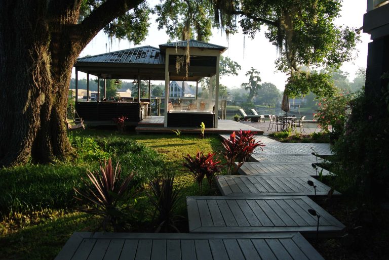 Example of a mid-sized trendy backyard outdoor kitchen deck design in New Orleans with a roof extension