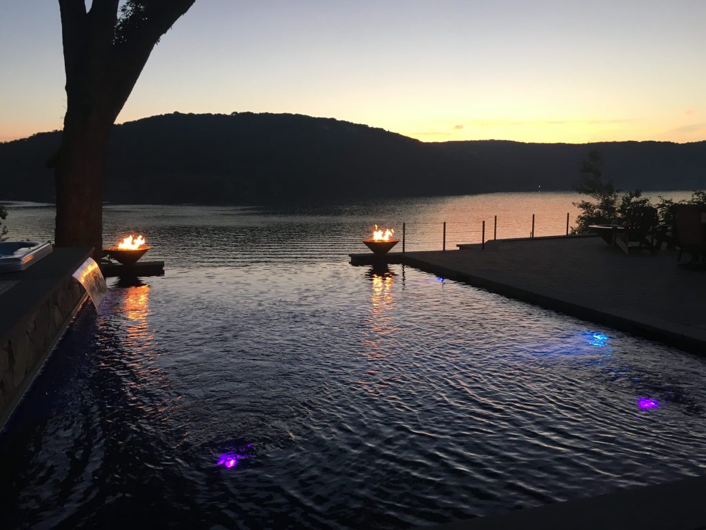 Example of a mid-sized trendy backyard stone and rectangular infinity pool fountain design in New York
