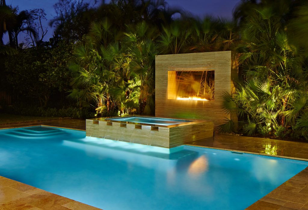 Example of a mid-sized trendy backyard stone and rectangular lap pool fountain design in Miami