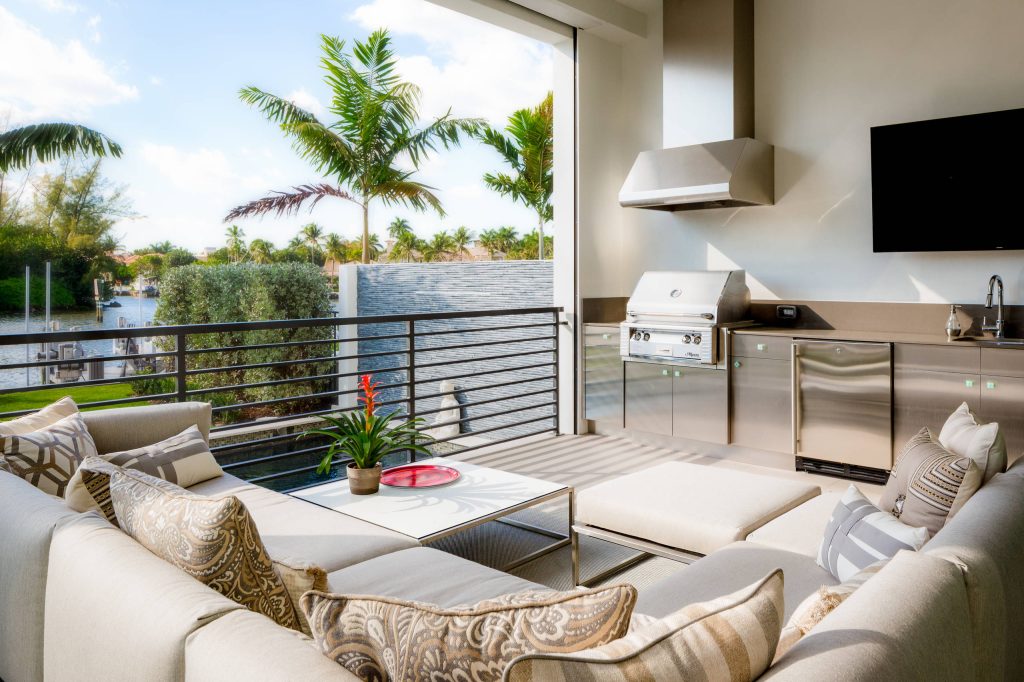 Example of a mid-sized trendy outdoor kitchen deck design in Miami with a roof extension