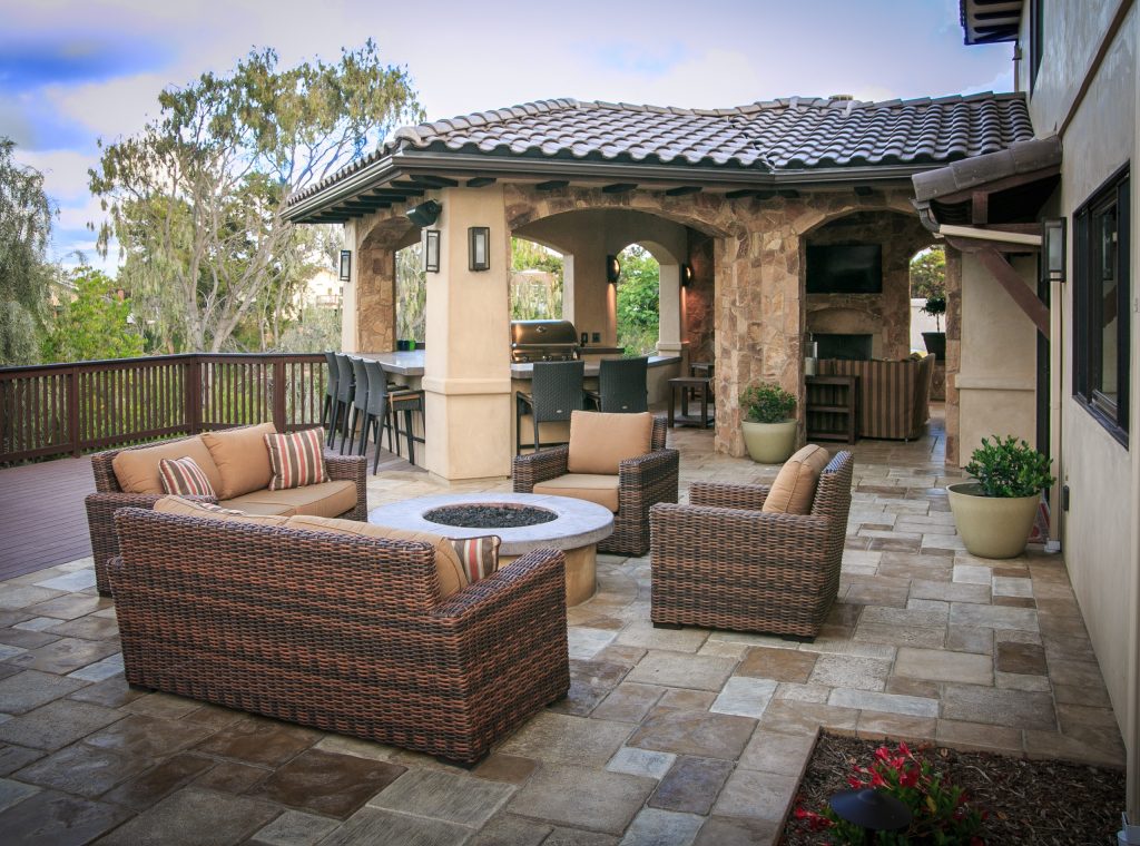 Example of a mid-sized tuscan backyard concrete paver patio kitchen design in San Diego with a roof extension