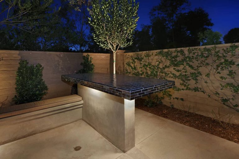 Example of a mid-sized tuscan backyard stamped concrete patio kitchen design in Orange County with no cover