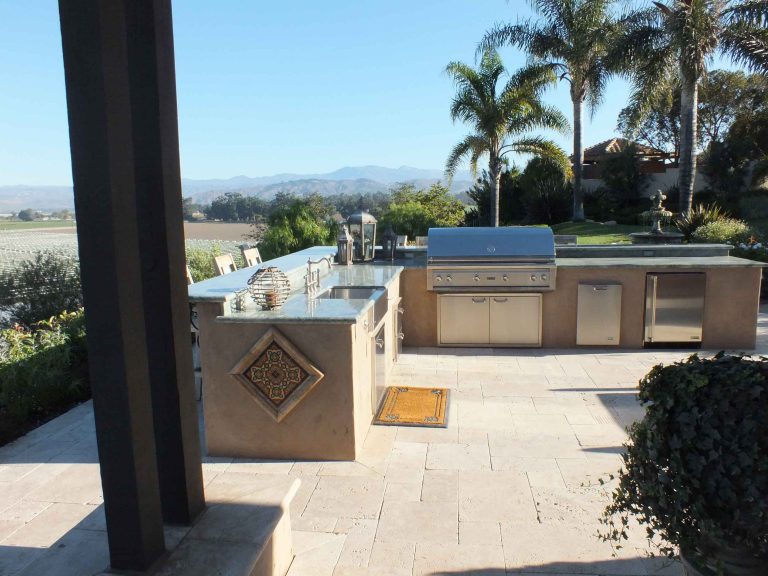 Example of a mid-sized tuscan backyard stone patio kitchen design in Santa Barbara with no cover