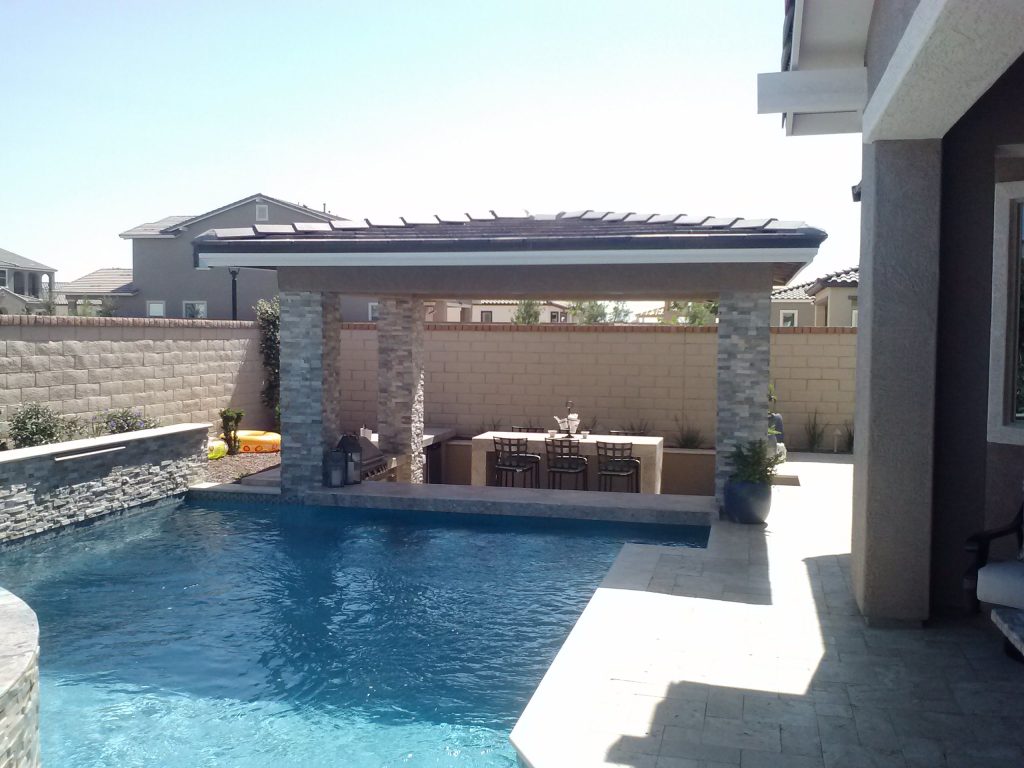 Example of a mid-sized tuscan backyard tile and custom-shaped pool house design in Phoenix