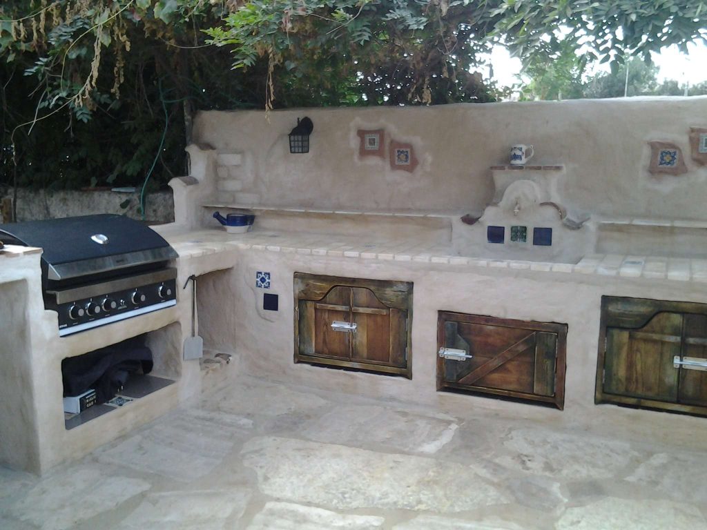 Example of a mid-sized tuscan backyard tile patio kitchen design in Los Angeles with no cover